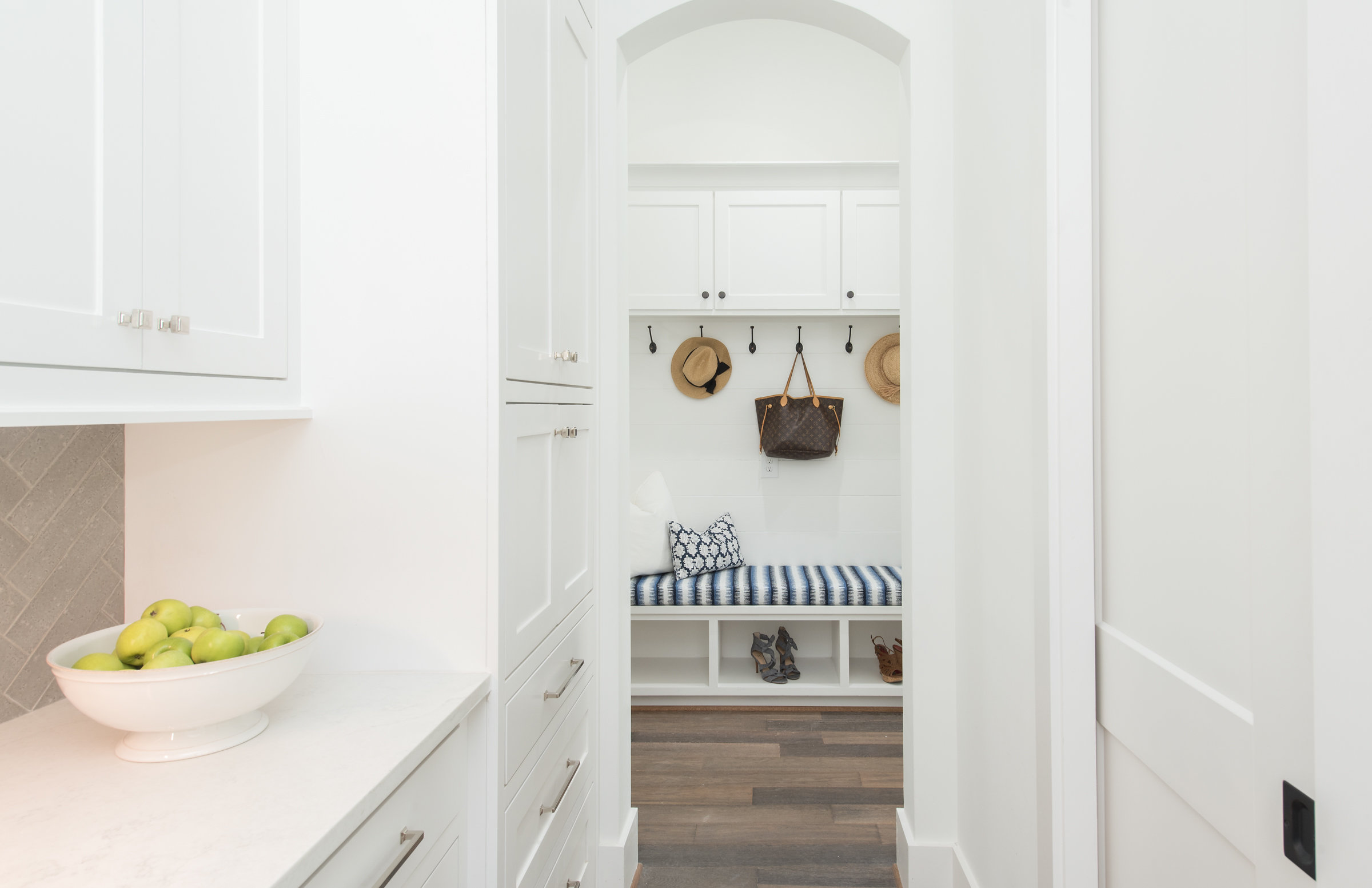 White mudroom with arched entry
