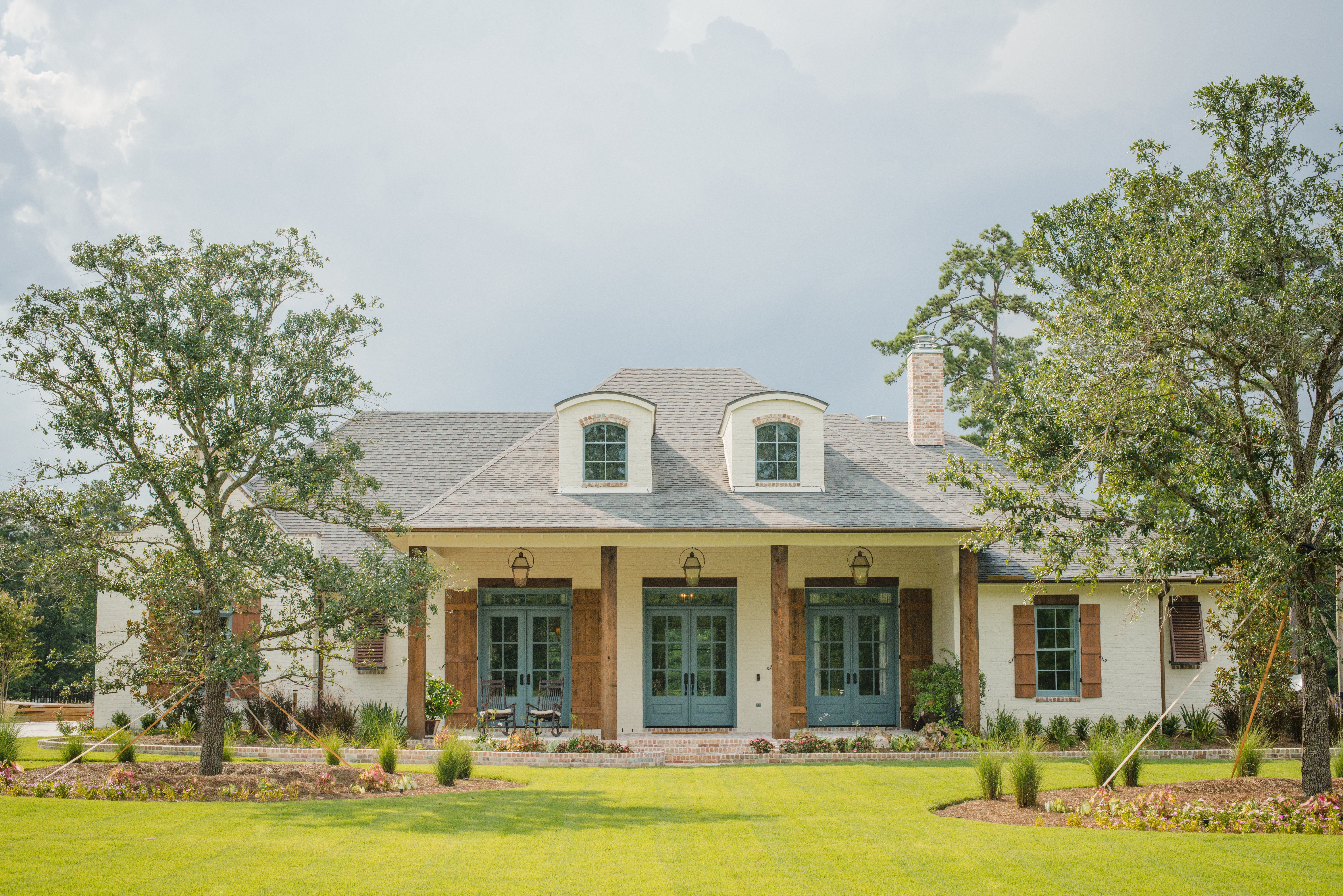Estate home exterior with covered porch and dormers